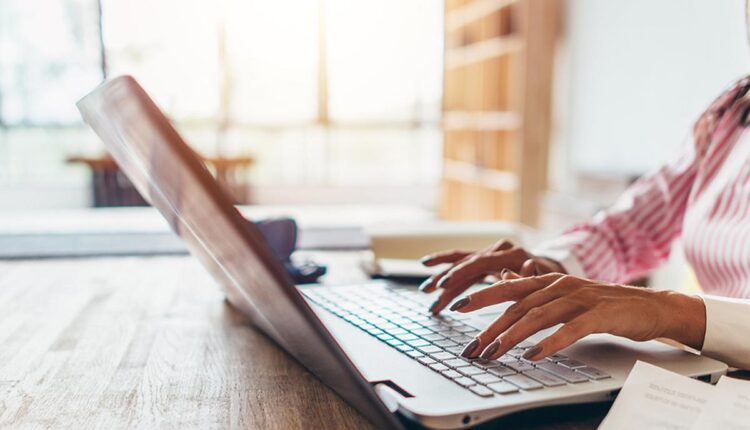 Woman working from home using notebook computer.